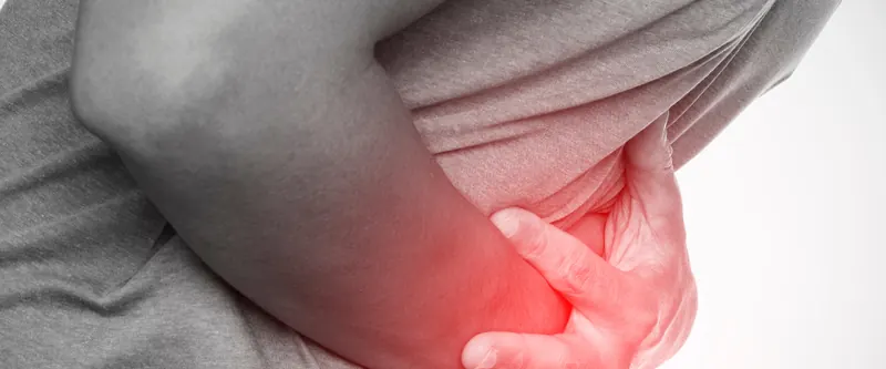 Persona tomándose la zona baja del abdomen con el dolor resaltado